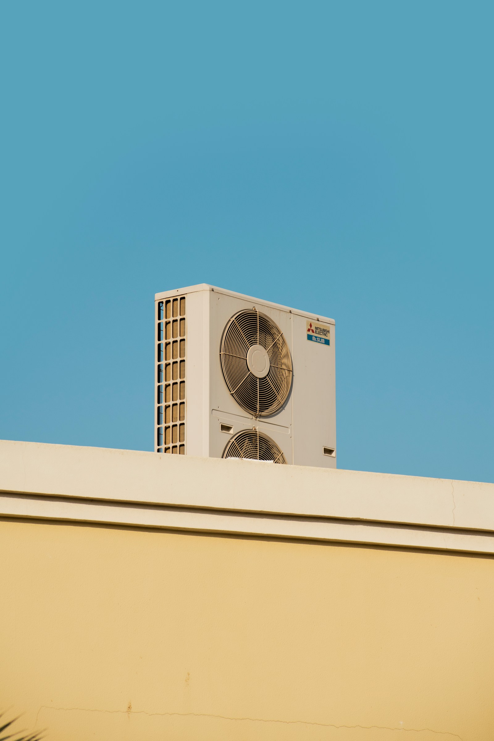 Air conditioning unit on a rooftop against a clear sky